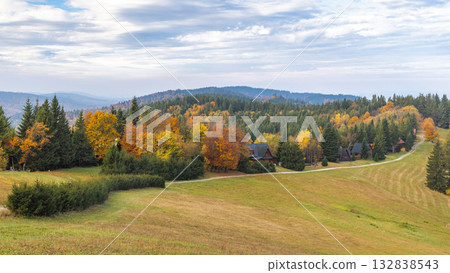 Scenic fall landscape with rolling hills colorful trees and cozy cabins nestled among the foliage in a serene countryside setting. Scenic fall landscape with rolling hills colorful trees and cozy cabins nestled among the foliage in a serene countryside setting. 132838543