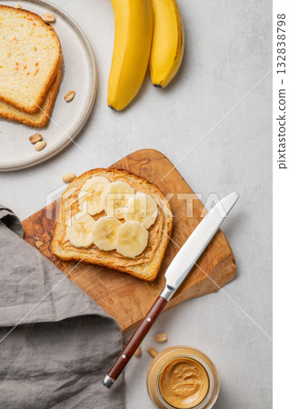 Peanut butter toast and banana on a wooden board  on a light background 132838798