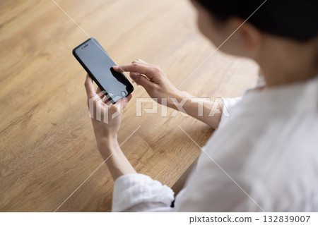 Close-up of a woman's hand operating a smartphone Close-up of a woman's hand operating a smartphone 132839007