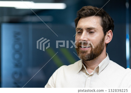A close-up photo of a young man sitting at his workplace, eyes closed, resting and dreaming. 132839225