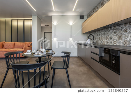 Modern Kitchen Interior with Patterned Tiles and Orange Sofa 132840257