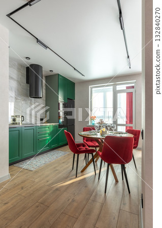 Modern Kitchen Interior with Green Cabinets and Red Velvet Chairs 132840270