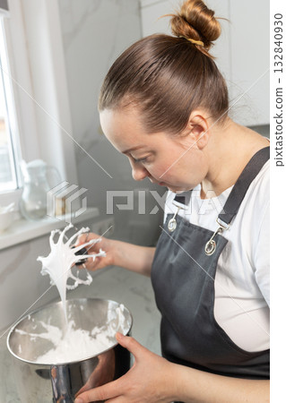 Pastry Chef Skillfully Preparing Meringue in a Modern Kitchen 132840930