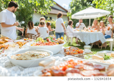 Family enjoying backyard barbecue during summer gathering with pastel decorations 132841654