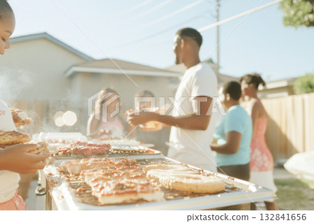 Family enjoying backyard barbecue during summer gathering with pastel decorations 132841656