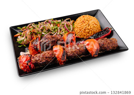 Delicious grilled kebabs served with rice and fresh salad in a vibrant setting 132841869
