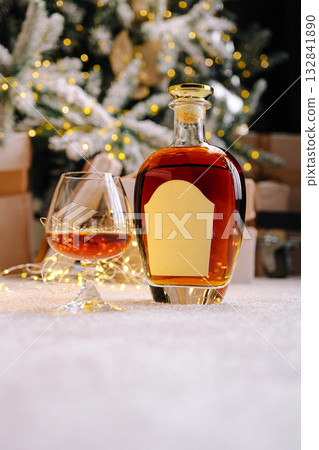 Enjoying a glass of fine whiskey beside a decorated Christmas tree 132841890