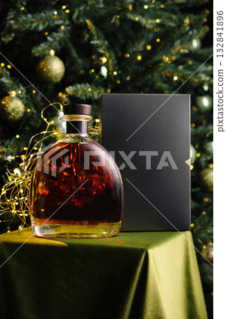 Elegant bottle of whiskey with festive decorations and a gift box Elegant bottle of whiskey with festive decorations and a gift box 132841896
