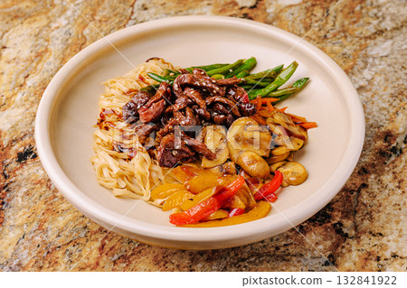 Delicious stir-fry with vegetables and noodles served in a bowl 132841922