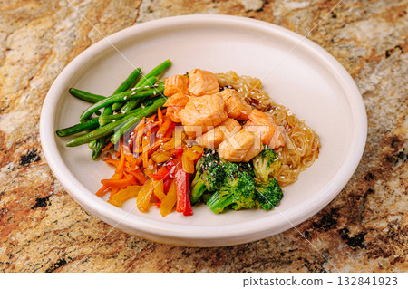 Colorful salmon and vegetable dish on a marble table close up Colorful salmon and vegetable dish on a marble table close up 132841923