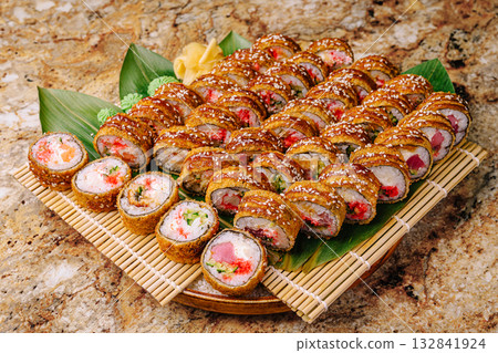 Sushi platter featuring a variety of colorful rolls on bamboo mats Sushi platter featuring a variety of colorful rolls on bamboo mats 132841924