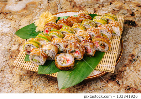 Sushi platter featuring colorful rolls arranged on bamboo leaves Sushi platter featuring colorful rolls arranged on bamboo leaves 132841926