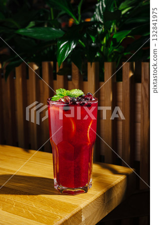 Refreshing crimson drink with mint and berries on wooden table Refreshing crimson drink with mint and berries on wooden table 132841975