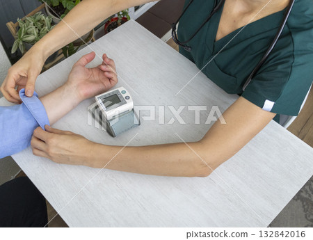 Female doctor measuring blood pressure of the patient 132842016