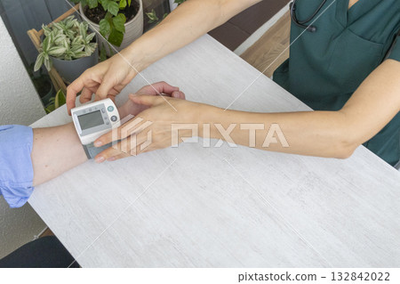 Female doctor measuring blood pressure of the patient Female doctor measuring blood pressure of the patient 132842022