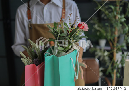 A small business owner, a florist or a gift shop worker preparing a customer's order. 132842040