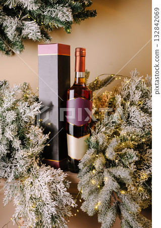 Festive display of wine bottle and holiday greenery with lights Festive display of wine bottle and holiday greenery with lights 132842069