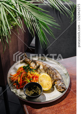 Freshly grilled fish served with colorful vegetable salad and lime Freshly grilled fish served with colorful vegetable salad and lime 132842075