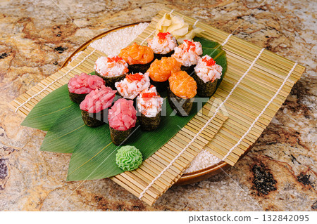 Fresh sushi platter featuring various types of seafood on bamboo mat 132842095