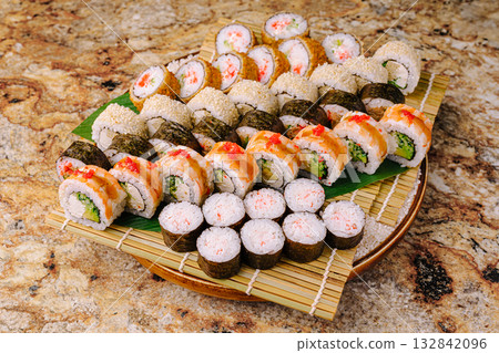 Sushi platter with various rolls presented on a wooden board 132842096