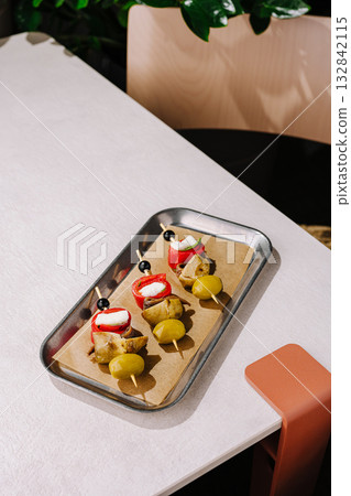 Delicious appetizer platter with skewers served in a modern cafe setting 132842115