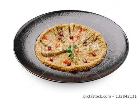 Delicious traditional dish served on elegant black plate with colorful garnishes 132842131