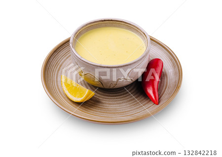Delicious creamy soup served in a rustic bowl with lemon and chili pepper Delicious creamy soup served in a rustic bowl with lemon and chili pepper 132842218