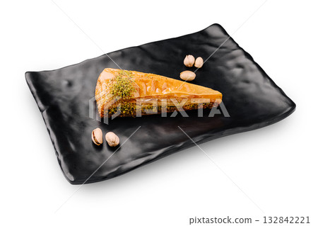 Delicious baklava served on a sleek black plate with pistachios Delicious baklava served on a sleek black plate with pistachios 132842221