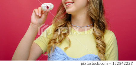 Smiling girl holding dessert with berry filling, close-up, colorful background 132842227