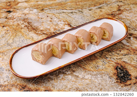 Delicious dessert rolls with banana and chocolate on elegant plate Delicious dessert rolls with banana and chocolate on elegant plate 132842260