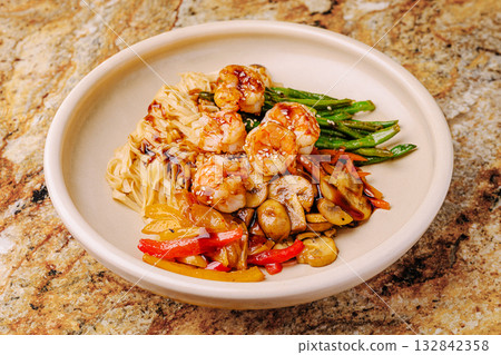 Delicious shrimp stir-fry served on a smooth marble table Delicious shrimp stir-fry served on a smooth marble table 132842358