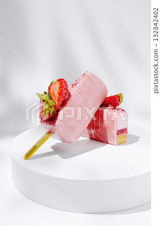 Delicious strawberry ice cream pops on a white platform in bright light 132842402
