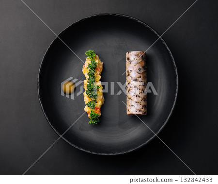 Gourmet sushi dish presented on a black plate with colorful ingredients 132842433