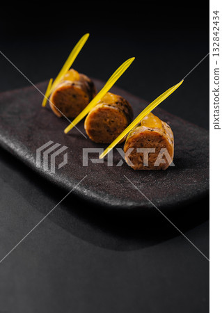 Innovative dish featuring unique flavors served on a dark platter Innovative dish featuring unique flavors served on a dark platter 132842434