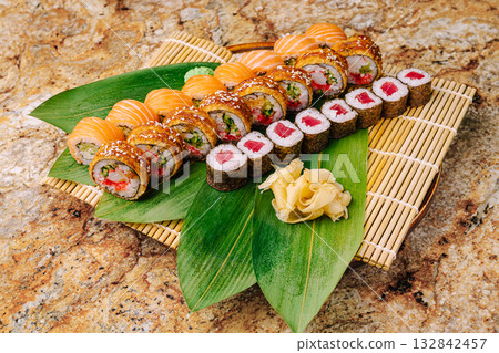 Sushi platter featuring assorted rolls with fresh ingredients on a bamboo mat Sushi platter featuring assorted rolls with fresh ingredients on a bamboo mat 132842457