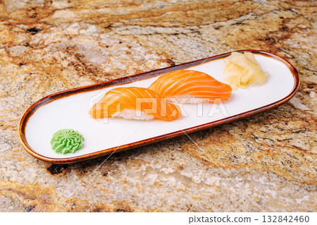 Fresh salmon sushi served on a stylish plate with wasabi and pickled ginger Fresh salmon sushi served on a stylish plate with wasabi and pickled ginger 132842460