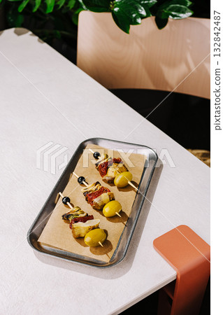 Delicious skewers served on a tray in a cozy restaurant setting Delicious skewers served on a tray in a cozy restaurant setting 132842487