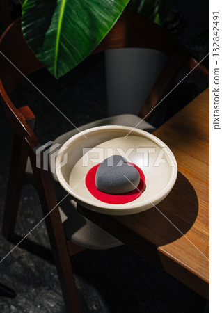 A minimalist dessert shaped like a heart, resting on vibrant red sauce 132842491