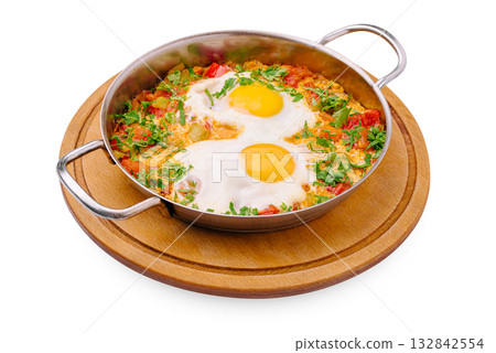 Delicious shakshuka served in a pan with fresh vegetables and herbs Delicious shakshuka served in a pan with fresh vegetables and herbs 132842554
