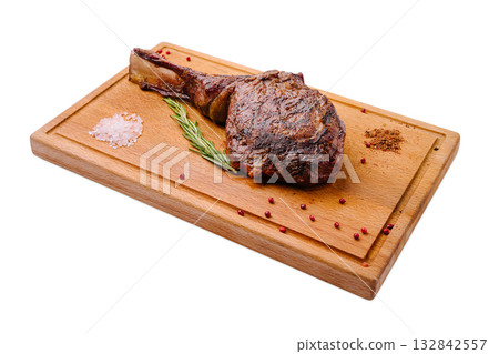 Juicy ribeye steak with seasoning served on a wooden cutting board Juicy ribeye steak with seasoning served on a wooden cutting board 132842557