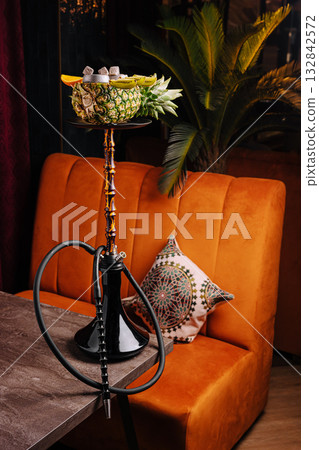 Hookah with fruits served on a table in a cozy lounge setting at night Hookah with fruits served on a table in a cozy lounge setting at night 132842572