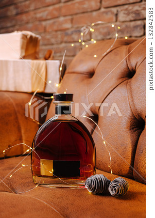 Elegant whiskey bottle with decorative lights near stacked wooden boxes 132842583
