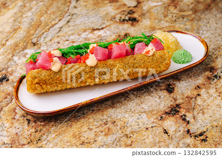 Delicious sushi roll with seared tuna and fresh toppings on a plate Delicious sushi roll with seared tuna and fresh toppings on a plate 132842595
