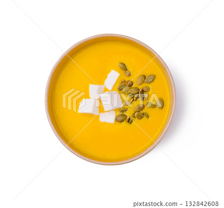 Bright orange soup with cheese and seeds in a simple bowl 132842608