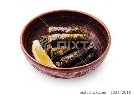 Delicious dolma served with lemon wedges in a rustic bowl 132842618