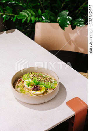 Delicious bowl of healthy oatmeal topped with fresh fruits and seeds 132842625