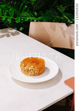Delightful dessert served on a white plate in a cozy cafe setting Delightful dessert served on a white plate in a cozy cafe setting 132842630