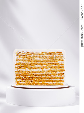 Layered cake displayed on a pedestal with minimalistic background Layered cake displayed on a pedestal with minimalistic background 132842632