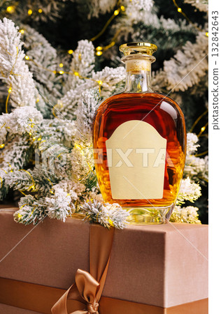 Amber spirit on a gift box with a Christmas tree backdrop Amber spirit on a gift box with a Christmas tree backdrop 132842643