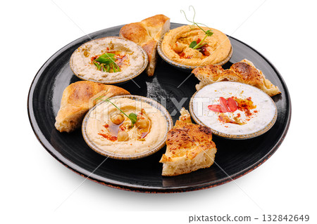 Delicious Middle Eastern dips with pita served on a dark plate Delicious Middle Eastern dips with pita served on a dark plate 132842649